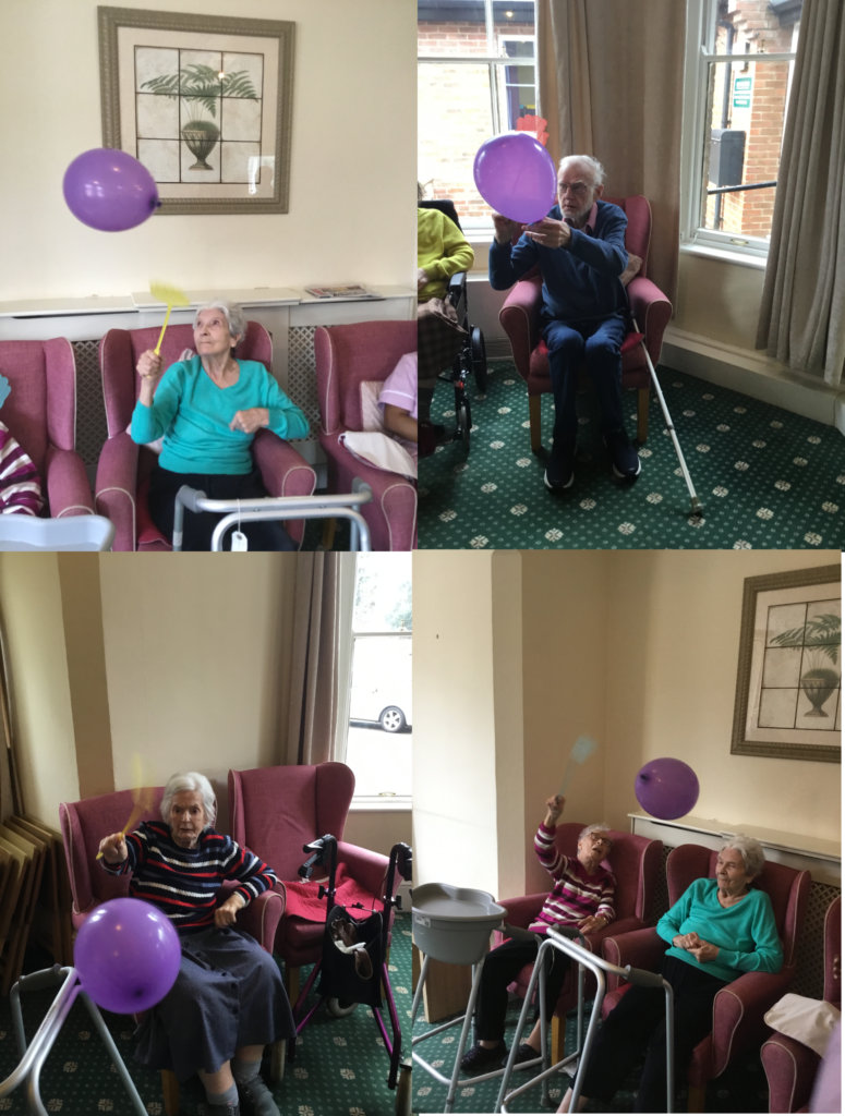 Residents enjoy a game of balloon tennins usinf fly swatters as raquets.